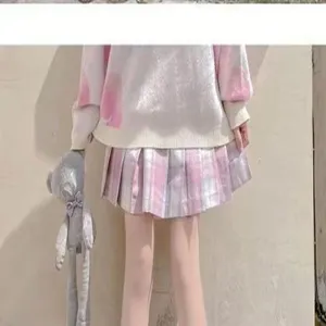 Japanese style sweet knit sweater and plaid pleated skirt detail view with plush toy