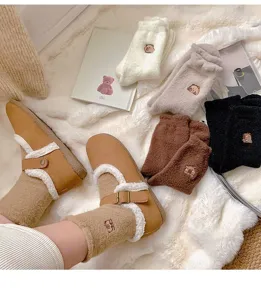 Detail view of cute winter thick fluffy bear embroidered socks and cozy plush shoes set.