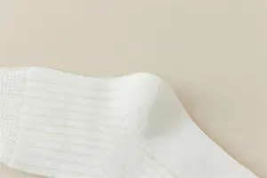 White ribbed knit sock detail close-up, soft cotton texture, simple elegant daily wear style.