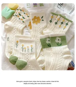 Detailed view of women's mid-tube socks featuring cute green and yellow floral embroidery.