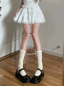 Detailed view of white mesh calf stacking socks paired with black Mary Jane shoes.
