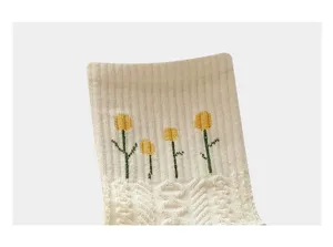 White knitted mid-tube socks featuring cute yellow flower embroidery and chic lace details.