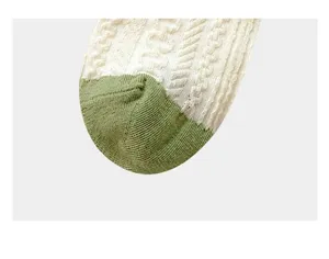 Close up detail of women green and white mid tube cable knit socks fashionable style.