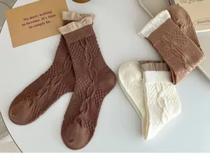 Vue détaillée de chaussettes en tricot pour femmes avec revers, tons marron et blancs.