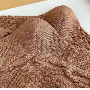 Vue de détail en tissu tricoté marron avec une texture douce et un design élégant.