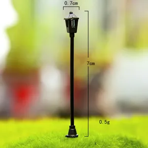 Detailed close-up of a miniature black garden street lamp for DIY moss micro landscape decoration.