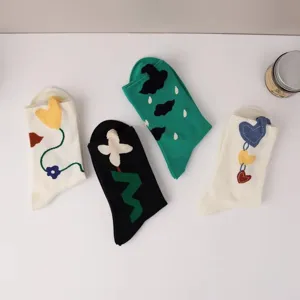 Detail view of cute crew socks with 3D flower, cloud and heart embroidery, cozy style.