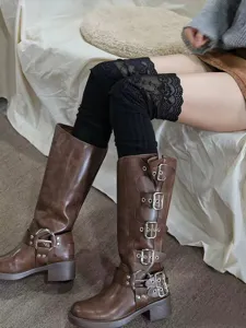 Close-up of black lace over-the-knee socks and brown buckle boots in chic outfit scene.