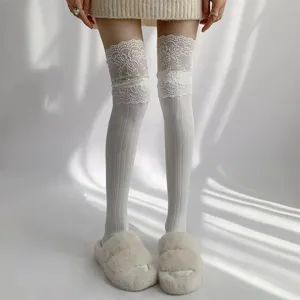 Detailed view of white over-the-knee socks featuring delicate lace cuffs and ribbed knit texture.