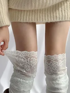 Detailed shot of white lace over-the-knee socks featuring delicate floral patterns.