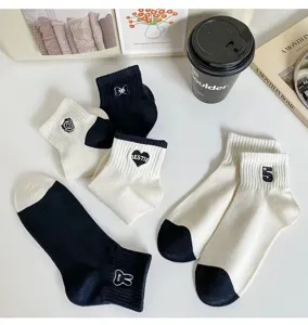 Detailed view of black and white cotton short socks with cute embroidery details.