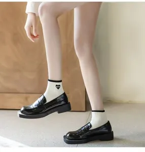 Detail shot of women's fashion academy style short socks paired with trendy black platform loafers.