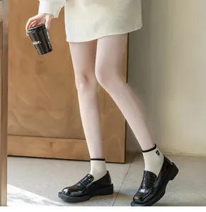 Close-up view of black and white college style short socks featuring cute heart details.