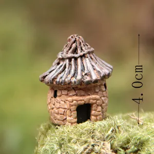 Primer plano de estatuilla miniatura de casa con techo de paja de resina para jardin.