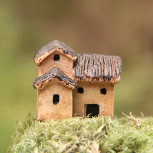 Primer plano de casita en miniatura de resina, ideal para jardinería de micropaisaje.