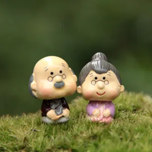 Detaillierte Nahaufnahme von niedlichen Miniatur-Alten-Paar-Figuren auf Moos für Sukkulenten-DIY.