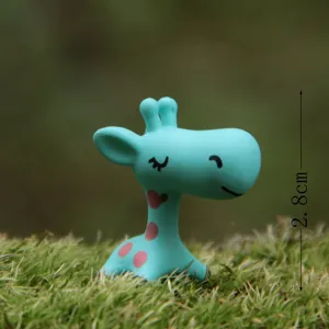 Detalle de estatuilla de jirafa cian en miniatura para decoracion de jardin de suculentas.