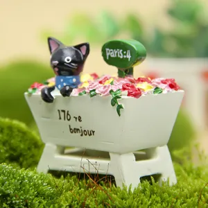 Primo piano dettagliato di una simpatica statuetta di gatto nero in resina con rose.