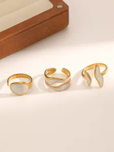 Gedetailleerd overzicht van drie minimalisten roestvrijstalen open ringen met witte druppelolie.