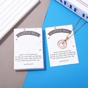 Detailed view of the pocket hug heart pendant necklace set with warm message card, clean flat lay.