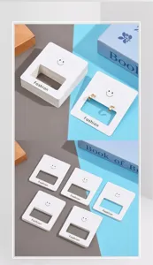 Detail view of white earring display cards with cute smiley face design and fashion text.