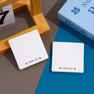 White square earring display cards with thank you print for jewelry packaging and retail use.