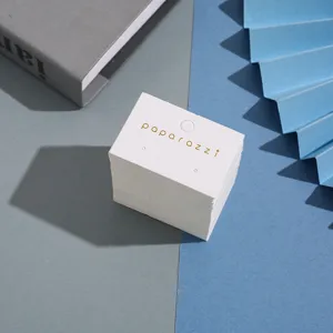 Gros plan détaillé de cartes de présentation de boucles d'oreilles avec logo doré élégant.