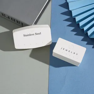 Detailed shot of white paper jewelry display cards with multi-holes for earrings and necklaces.