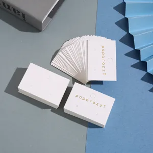 Cartes de présentation de boucles d'oreilles en papier blanc avec logo en feuille d'or.