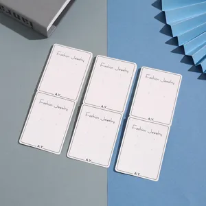 Close-up detail of white paper earring display cards featuring punched holes for jewelry.