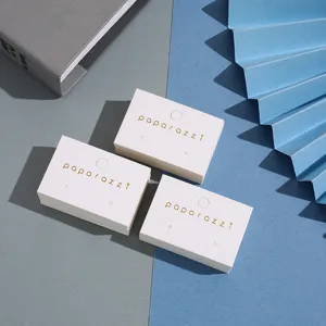 Detail de cartes de presentation de boucles d'oreilles blanches avec logo dore et perforations.