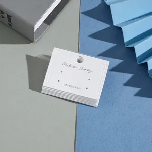 Detail view of white paper earring cards with multi holes for jewelry packaging display.