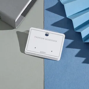 Detailed shot of white earring display cards with hanging holes for jewelry packaging.