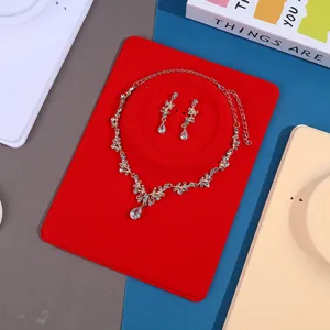Gold rhinestone necklace and earrings jewelry set displayed on a red velvet neck card.