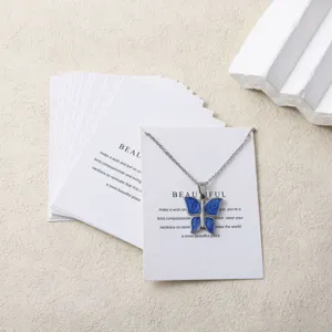 Collier pendentif papillon bleu minimaliste avec cartes de présentation et emballage.