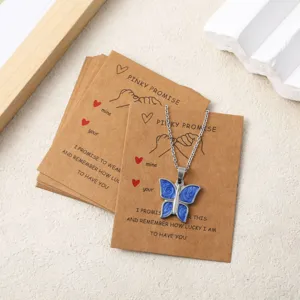 Blue butterfly pendant necklace on craft paper display card with romantic promise quote.