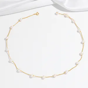 Delicate gold chain station necklace featuring natural freshwater pearls, elegant detail.