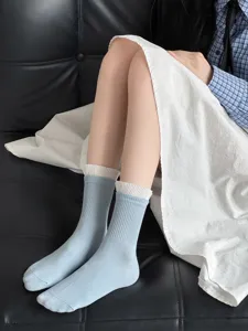 Women's cotton mid-tube socks featuring a chic white ruffled cuff and ribbed blue design.