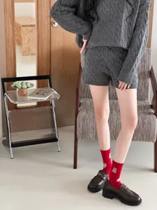 Detail view of cute winter rabbit jacquard mid-tube socks paired with cozy knit outfit.