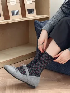 Close-up van stijlvolle middelhoge sokken met ruitpatroon gecombineerd met gezellige grijze schoenen.