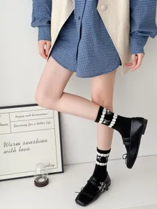Detailed shot of Japanese style college bow mid-tube socks paired with black Mary Jane shoes.