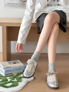 Vista dettagliata di calzini corti grigi in cotone a coste abbinati a scarpe da ginnastica.