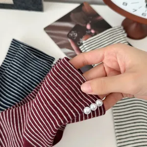 Knit striped socks detail view featuring elegant pearl embellishments and soft fabric.