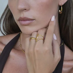 Detailaufnahme minimalistischer goldener Titanstahl-Ringe, eleganter Modeschmuck für Damen.