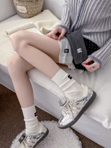 Primo piano dettagliato di eleganti calze a coste bianche da donna con etichetta nera chic.