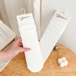 White mid-tube ruffle socks detail featuring delicate bow patterns and thin breathable fabric.