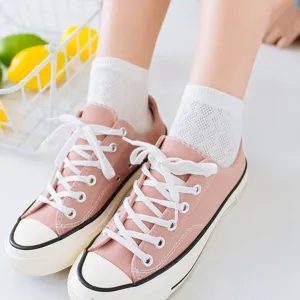 Women breathable mesh short socks with casual canvas sneakers and fruit basket background.