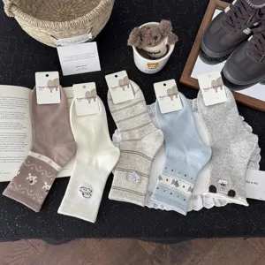 Detail shot of cute embroidered cotton mid-calf socks in various colors and fun cartoon patterns.