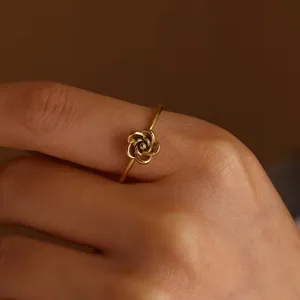 Primo piano di anello fiore di rosa dorato in acciaio inossidabile, gioiello dito elegante.