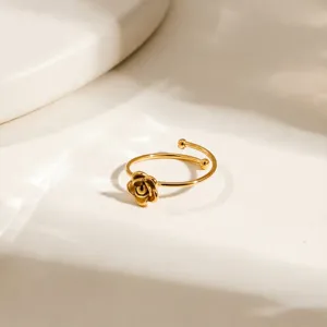 Vista dettagliata anello aperto con fiore di rosa in acciaio dorato, gioiello elegante.
